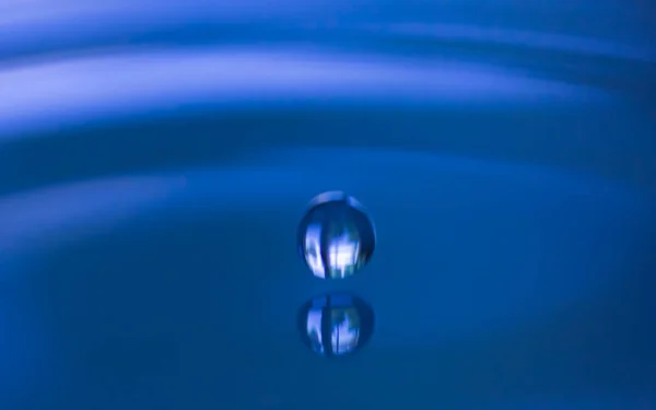 水とスプラッシュ創造的なフォームでライトブルーの色のドロップ — ストック写真