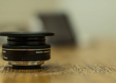 Riga, Letonya - 23 Eylül 2020: Canon asal lensi 24 mm küçük ölçekli, masadaki filtre adaptörlü gözleme