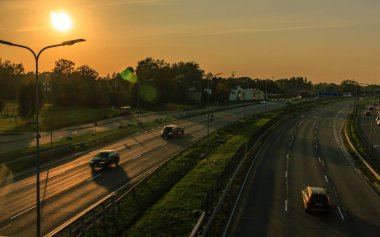 Riga, Letonya - 23 Eylül 2020: Otoyolda gün batımı, yolda bulanık arabalar, köprüden manzara