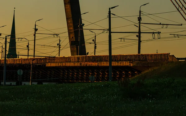 Riga, Letonya - 17 Temmuz 2020: Gündoğumunda başkentin köprü manzarası, fenerler ve elektrik hatları