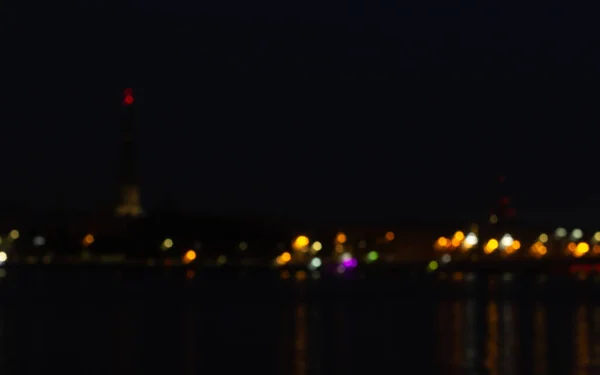 Gece ışıkları ve fener izleri karanlık gecede, şehir görüşü bulanık.
