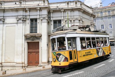 Lizbon Katedrali 'nin önündeki bir sokakta tarihi tramvaylar. Portekizli likör reklamlı tramvay Beirao