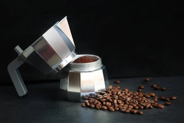 Kávé egy fazékban kávébabbal és őrölt kávéval homályos sötét háttérrel. Friss, hagyományos olasz eszpresszó kávé készítése. Stock Kép