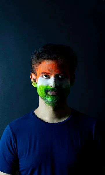 Young man posing with face painted tricolor on Indian independence day or Republic day greeting