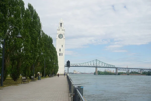Montreal Saat Kulesi ve Jacques Cartier Köprüsü Old Port, Montreal, Kanada. Arka plan mavi bulutlu bir gökyüzü. Sağ tarafta Saint Laurent Nehri var..