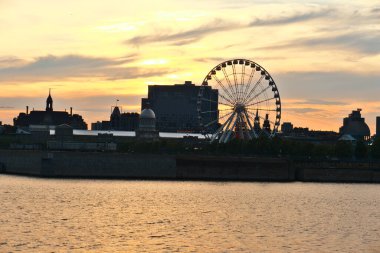 Gün batımında Montreal Eski Limanı 'nın ufuk çizgisi. Ön plan Saint Laurent nehri..