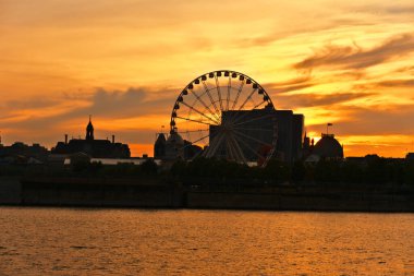 Montreal Grand Ferris Wheel, Old Port 'ta gün batımında. Saint Laurent nehrindeki güneş ışınlarının yansımaları.