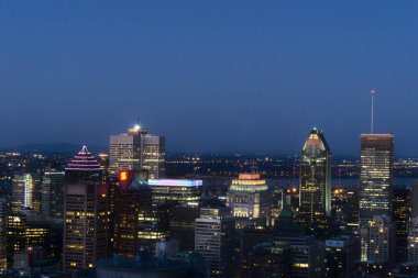 Alacakaranlık zamanı, Montreal, QC, Kanada 'da bir dağdan alınan gökdelenleri, binaları ve sokakları aydınlatan uzun bir gökyüzü manzarası