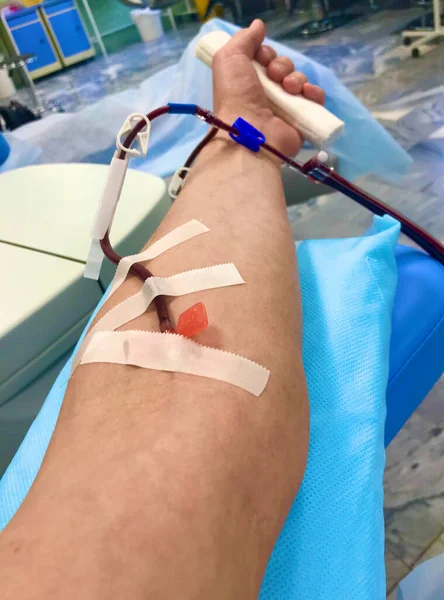a blood donors arm during plasmapheresis in a hospital, and the needle penetrated the skin of a mans arm. blood donor for blood transfusion to the hospital with a needle in his hand. A man gives antibodies to Covid