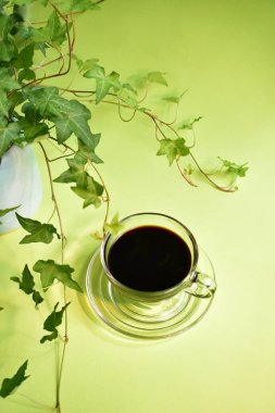 Yeşil işyeri, koyu kahve fincanlı yeşil ofis masası, pastel yeşil arka plan, taze, yeni hayat, barış, çevre dostu