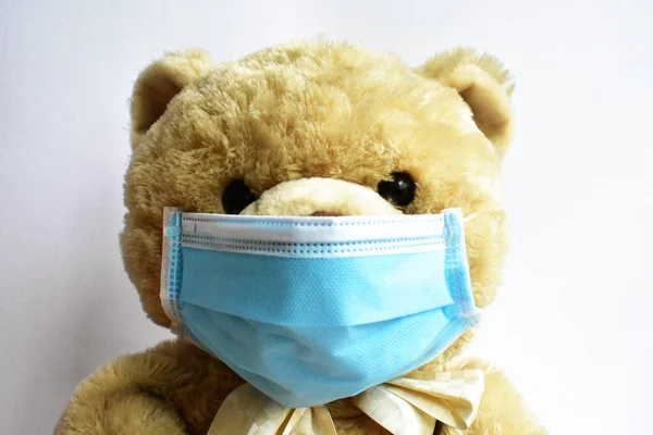 白い背景に青い医療用マスクでかわいい茶色のクマ 医者熊は病気のウイルスの普及のためのフェイスマスク保護を身に着けているCov 2コロナウイルス病の隔離 安全な滞在 — ストック写真