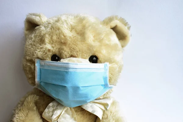 Cute brown bear with blue medical mask in white background. Doctor bear wearing face mask protective for spreading of disease virus CoV-2 Corona virus Disease quarantine, stay safe, children