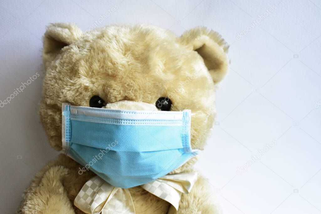 Cute brown bear with blue medical mask in white background. Doctor bear wearing face mask protective for spreading of disease virus CoV-2 Corona virus Disease quarantine, stay safe, children