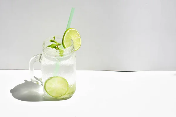 緑のレモンスライスとミントの葉を持つレモネードのメイソン瓶ガラス 白の背景に隔離された蜂蜜 夏のドリンク 新鮮な 自家製 クール フルーツジュース サイドビュー — ストック写真