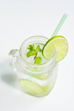 Yeşil limon dilimi ve nane yaprağı ile Mason kavanozu bardağı limonata, beyaz arka planda izole edilmiş bal, yaz içeceği, taze içecek, ev yapımı, soğuk, meyve suyu, yan görüş