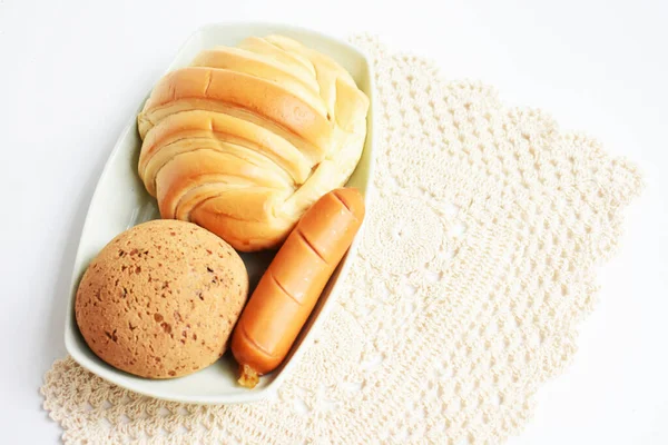Beautiful, delicious breakfast table, dish of sweet croissant, Korean sesame Mochi bread or Japanese Mochi bun, pig sausage white background, bakery, junk food, fast food