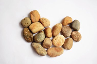 Taşlar / taşlar, beyaz arka planda kalp şeklinde çakıl taşları, aşk sembolü, sevgililer günü, aşk konsepti, zen ve meditasyon, soyut, antik konsept, Boho tarzı, Bohem arkaplan, klasik