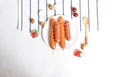 Düz konum, üst manzara, beyaz arka planda yiyecek ve içecek, ızgara sosisli lezzetli öğle yemeği ve kızarmış sosis, barbekü, bbq, hot dog, yağ, abur cubur, fast food, yemek, meşe palamudu,