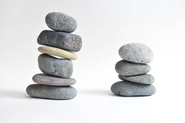 Yığın taşları beyaz arka planda izole edilmiş. Çakıl taşı kulesi. Denge ve uyum kavramı. Sakin ve ruh, spa taşları ve zen, barış, meditasyon, manevi ve soyut