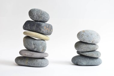 Yığın taşları beyaz arka planda izole edilmiş. Çakıl taşı kulesi. Denge ve uyum kavramı. Sakin ve ruh, spa taşları ve zen, barış, meditasyon, manevi ve soyut