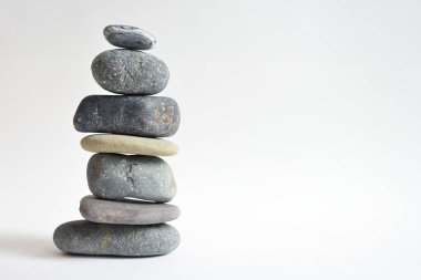 Yığın taşları beyaz arka planda izole edilmiş. Çakıl taşı kulesi. Denge ve uyum kavramı. Sakin ve ruh, spa taşları ve zen, barış, meditasyon, manevi ve soyut