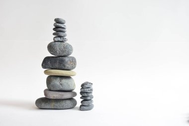 Yığın taşları beyaz arka planda izole edilmiş. Çakıl taşı kulesi. Denge ve uyum kavramı. Sakin ve ruh, spa taşları ve zen, barış, meditasyon, manevi ve soyut