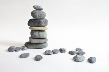Yığın taşları beyaz arka planda izole edilmiş. Çakıl taşı kulesi. Denge ve uyum kavramı. Sakin ve ruh, spa taşları ve zen, barış, meditasyon, manevi ve soyut