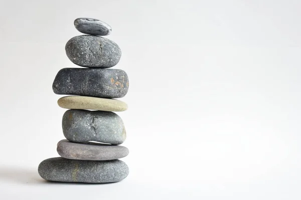 Yığın taşları beyaz arka planda izole edilmiş. Çakıl taşı kulesi. Denge ve uyum kavramı. Sakin ve ruh, spa taşları ve zen, barış, meditasyon, manevi ve soyut