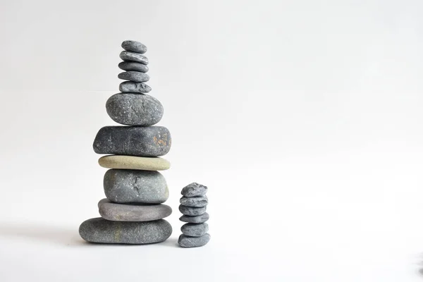 Yığın taşları beyaz arka planda izole edilmiş. Çakıl taşı kulesi. Denge ve uyum kavramı. Sakin ve ruh, spa taşları ve zen, barış, meditasyon, manevi ve soyut