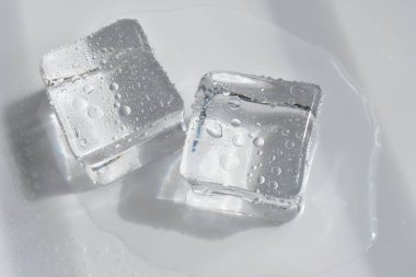 Gri renkli, beyaz arkaplan, kristal kaplı şeffaf buz küpleri