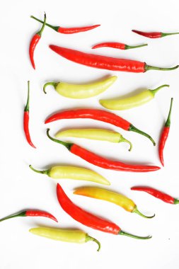Kırmızı biber, yeşil kırmızı biber dilimleri / beyaz arka planda yarı izole edilmiş, deri döşeme, üst manzara, beyaz masada Tayland biberi.