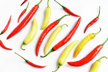 Kırmızı biber, yeşil kırmızı biber dilimleri / beyaz arka planda yarı izole edilmiş, deri döşeme, üst manzara, beyaz masada Tayland biberi.