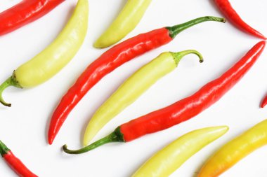 Kırmızı biber, yeşil kırmızı biber dilimleri / beyaz arka planda yarı izole edilmiş, deri döşeme, üst manzara, beyaz masada Tayland biberi.