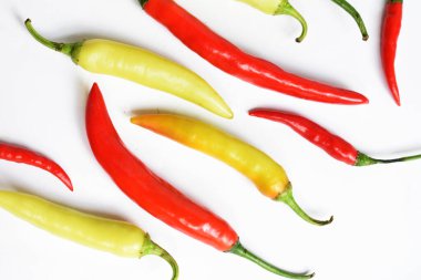 Kırmızı biber, yeşil kırmızı biber dilimleri / beyaz arka planda yarı izole edilmiş, deri döşeme, üst manzara, beyaz masada Tayland biberi.