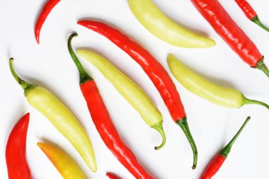 Kırmızı biber, yeşil kırmızı biber dilimleri / beyaz arka planda yarı izole edilmiş, deri döşeme, üst manzara, beyaz masada Tayland biberi.