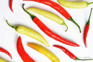 Kırmızı biber, yeşil kırmızı biber dilimleri / beyaz arka planda yarı izole edilmiş, deri döşeme, üst manzara, beyaz masada Tayland biberi.
