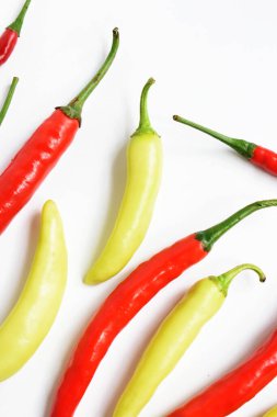 Kırmızı biber, yeşil kırmızı biber dilimleri / beyaz arka planda yarı izole edilmiş, deri döşeme, üst manzara, beyaz masada Tayland biberi.