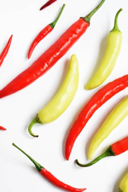 Kırmızı biber, yeşil kırmızı biber dilimleri / beyaz arka planda yarı izole edilmiş, deri döşeme, üst manzara, beyaz masada Tayland biberi.