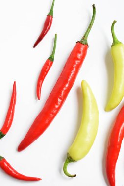 Kırmızı biber, yeşil kırmızı biber dilimleri / beyaz arka planda yarı izole edilmiş, deri döşeme, üst manzara, beyaz masada Tayland biberi.