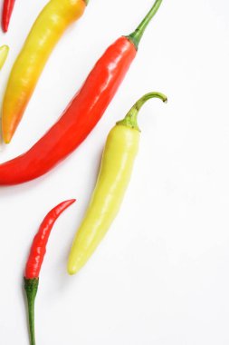 Kırmızı biber, yeşil kırmızı biber dilimleri / beyaz arka planda yarı izole edilmiş, deri döşeme, üst manzara, beyaz masada Tayland biberi.