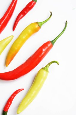 Kırmızı biber, yeşil kırmızı biber dilimleri / beyaz arka planda yarı izole edilmiş, deri döşeme, üst manzara, beyaz masada Tayland biberi.