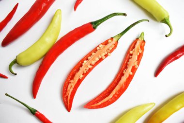 Kırmızı biber, yeşil kırmızı biber dilimleri / beyaz arka planda yarı izole edilmiş, deri döşeme, üst manzara, beyaz masada Tayland biberi.