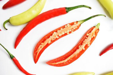 Kırmızı biber, yeşil kırmızı biber dilimleri / beyaz arka planda yarı izole edilmiş, deri döşeme, üst manzara, beyaz masada Tayland biberi.