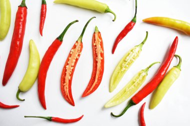 Kırmızı biber, yeşil kırmızı biber dilimleri / beyaz arka planda yarı izole edilmiş, deri döşeme, üst manzara, beyaz masada Tayland biberi.