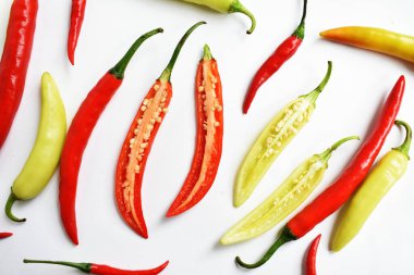 Kırmızı biber, yeşil kırmızı biber dilimleri / beyaz arka planda yarı izole edilmiş, deri döşeme, üst manzara, beyaz masada Tayland biberi.