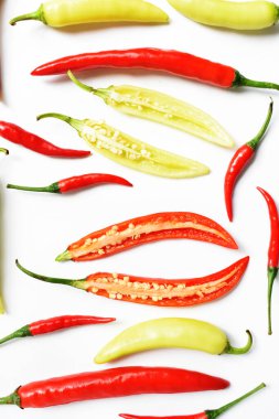 Kırmızı biber, yeşil kırmızı biber dilimleri / beyaz arka planda yarı izole edilmiş, deri döşeme, üst manzara, beyaz masada Tayland biberi.