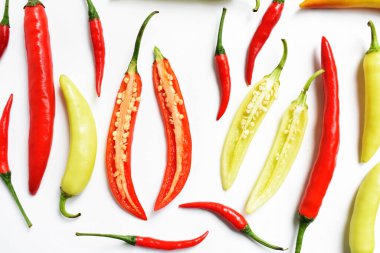 Kırmızı biber, yeşil kırmızı biber dilimleri / beyaz arka planda yarı izole edilmiş, deri döşeme, üst manzara, beyaz masada Tayland biberi.