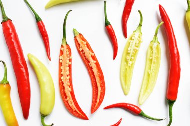Kırmızı biber, yeşil kırmızı biber dilimleri / beyaz arka planda yarı izole edilmiş, deri döşeme, üst manzara, beyaz masada Tayland biberi.