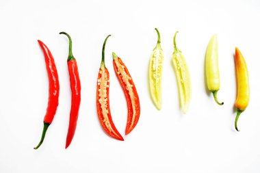 Kırmızı biber, yeşil kırmızı biber dilimleri / beyaz arka planda yarı izole edilmiş, deri döşeme, üst manzara, beyaz masada Tayland biberi.