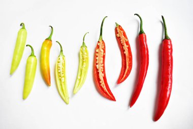 Kırmızı biber, yeşil kırmızı biber dilimleri / beyaz arka planda yarı izole edilmiş, deri döşeme, üst manzara, beyaz masada Tayland biberi.